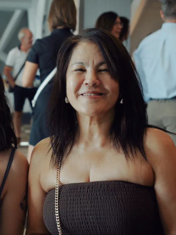 Una mujer sonriendo en un encuentro de la comunidad